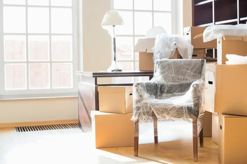 Room full of moving boxes and furniture packed for a move